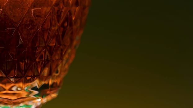Close-up of carbonated dark drink in glass. Stock clip. Gases in alcoholic drink on isolated background. Transparent glass with carbonated dark drink in bar.
