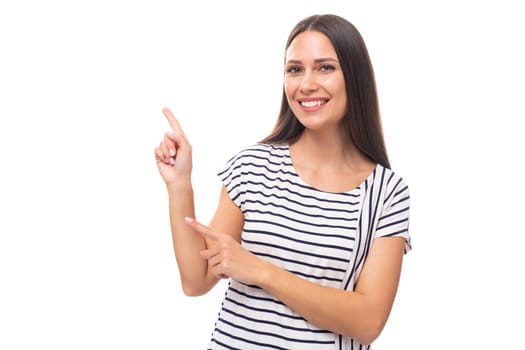 young pretty european brunette woman in a striped sweater gesturing actively on a white background with copy space.