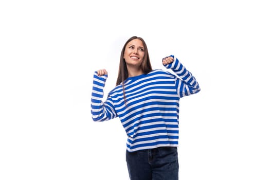positive smiling young brunette woman in a striped blue blouse on a white background with copy space.