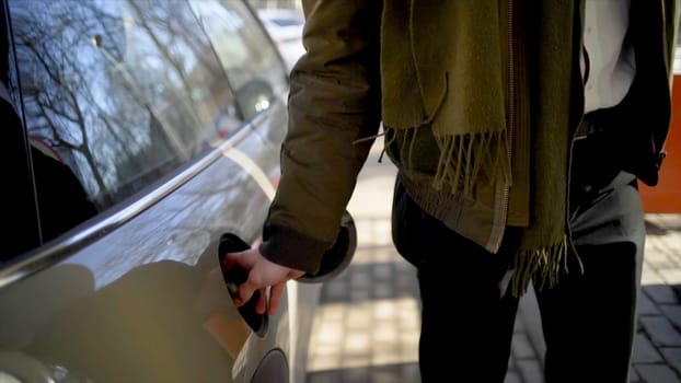Man inserts hose into car at gas station. Action. Man nervously and quickly refuels car at gas station. Filling up car during long chase.