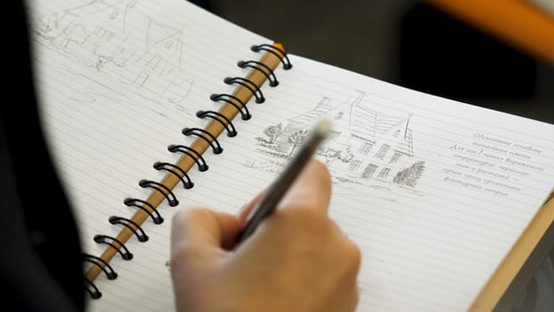 Male hands drawing pictures in notebook, close up 4K