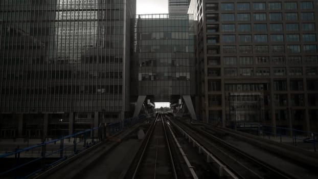 Skytrain tracks in business district of metropolis. Action. Skytrain in big city with skyscrapers in cloudy weather. Skytrain passes by skyscrapers with gloomy atmosphere. Gotham city.