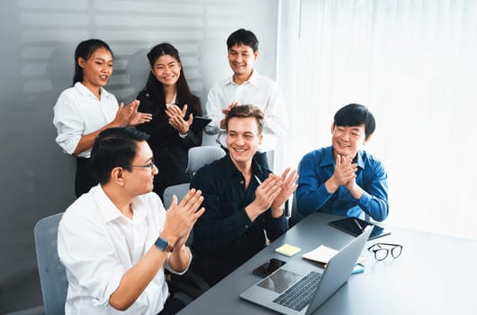 Diverse group of office worker and employee applauding, happily collaborate on strategic business marketing planning. Teamwork and positive attitude create productive and supportive workplace. Prudent