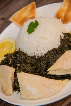 Lebanese recipe Mouloukhia , Melokhiyah, corete leaf and coriander rice chicken, grilled pita. High quality photo