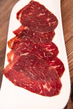 Dry-cured Spanish ham, Serrano ham, Bellota ham, Italian prosciutto crudo or Parma ham, wagyu slice. High quality photo