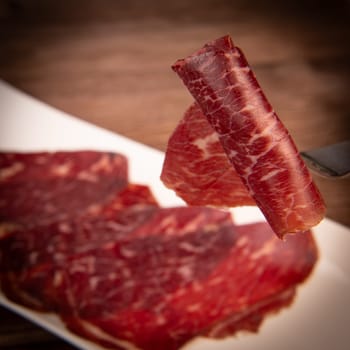 Dry-cured Spanish ham, Serrano ham, Bellota ham, Italian prosciutto crudo or Parma ham, wagyu slice. High quality photo