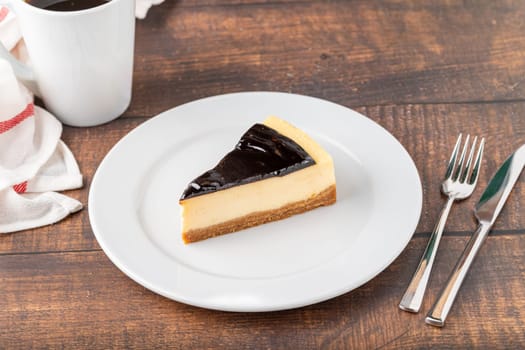 Chocolate cheesecake with brewing coffee on wooden table