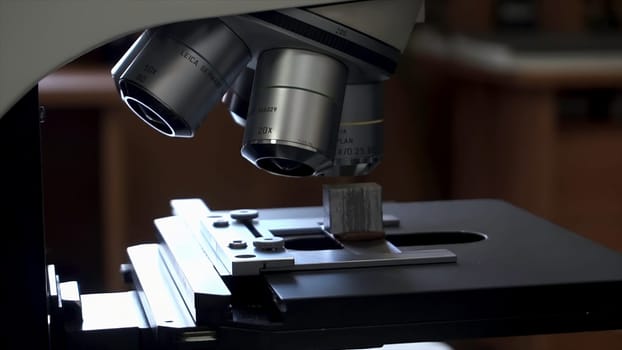 Close up for the microscope lens, science concept. Microscope standing on the table, scientific equipment.