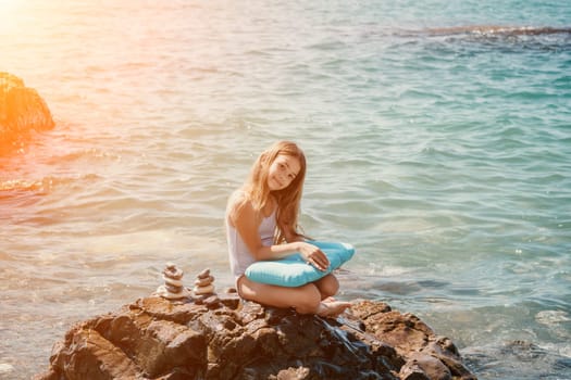 Balanced Pebbles Pyramid on the Beach on Sunny Day and Clear Sky at Sunset. Blue Sea on Background Selective focus, zen stones on sea beach, meditation, spa, harmony, calm, balance concept.