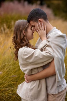 Young Cute Female Hugs Boyfriend. In Autumn Outdoor. Lovers Walking in Park. Attractive Funny Couple. Lovestory in Forest. Man and Woman. Cute Lovers in the Park. Family Concept. Happy Couple.