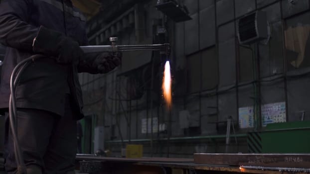 Welding worker works on metal structure in factory. Clip. Welding work with metal at factory. Metallurgical plant and welding works.