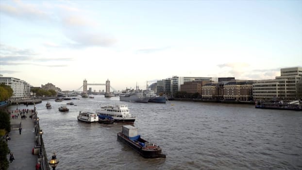 Canal in city on background of large bridge with towers. Action. Beautiful port channel is located in big city with beautiful bridge. Beautiful old architectural bridge with towers.