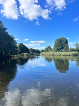 Wonderful panorama of the river. Trees are reflected in the water mirror. High quality photo