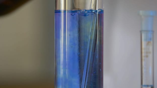 Scientist Pours Blue Pattern Chemicals Into In Flask. health care and medical concept. Scientist are certain activities on experimental science like mixing chemicals 4K