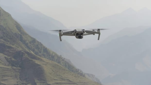 Flying drone in air. Action. Drone flies over beautiful mountain landscape on sunny day. Drone in air shoots mountain landscape.