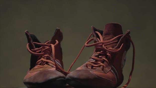 Red leather shoes for sports on a dark background. two shoes to fight standing on a grey background.