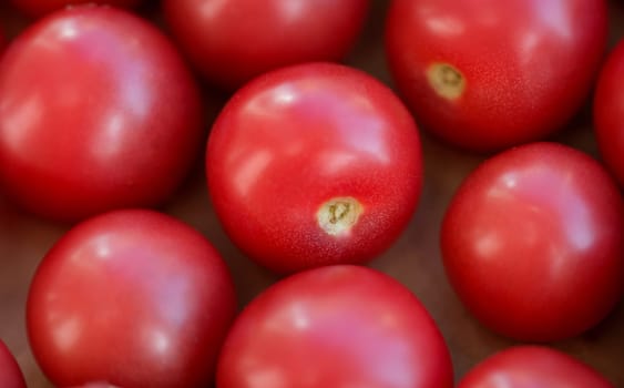 Ripe juicy healthy tomatoes in a box closeup. Natural oriental food and agriculture concept