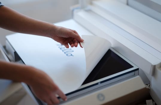 Tbilisi, Georgia - April 11, 2022: Woman removing protective film from New iMac monitor. iMac series of personal quality computers concept