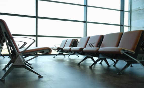 Empty brown leather chairs in airport lounge. Architecture of public buildings concept