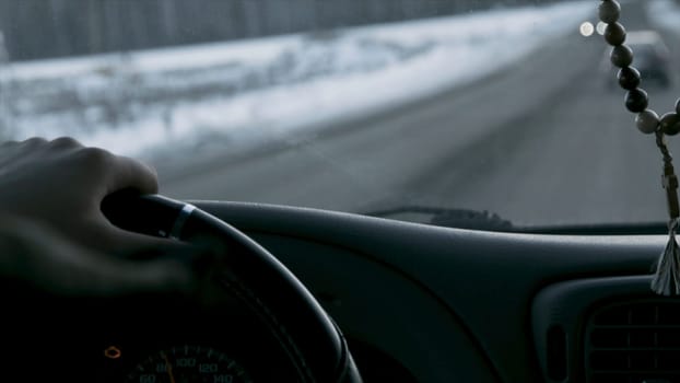 Car interior and winter road. Footage. Driver and passenger view from the cockpit of a car on the snowy road, back view p