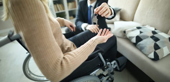 Agent hands over keys to accommodation of persons in wheelchair. Getting social housing concept