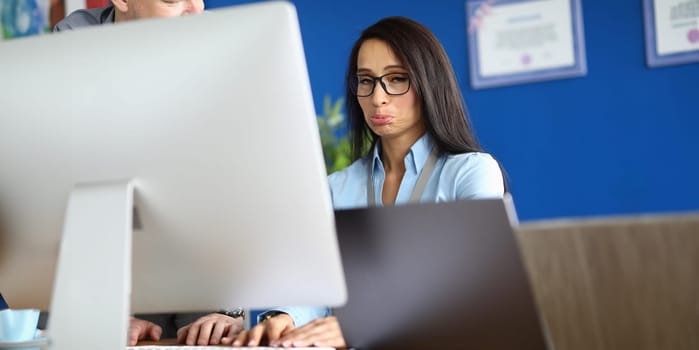 Offended woman works on computer in office. Emotions and business mistake concept