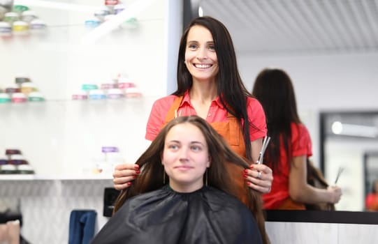 Professional hairdresser cuts female hair in salon. Beauty salon services and trendy haircuts concept