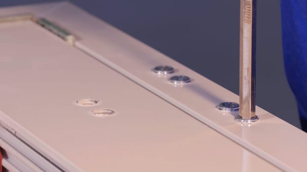 Installation Accessories For Plastic Pvc Windows. Screwdrivers or Drill. Male Hands Fasten Window Handle By Electric Screwdriver. Tempered float glass panels. Industry