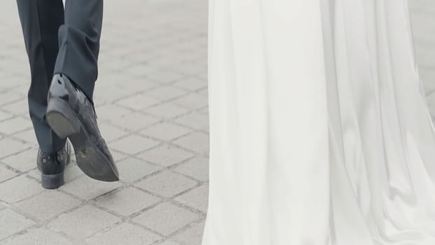 Detailed wedding photography. Action. The silhouette of the kissing newlyweds and their walk down the street in classic costumes. High quality 4k footage