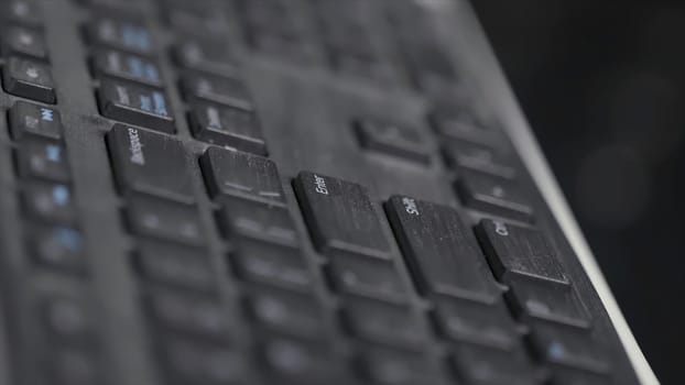 Close-up of finger over black laptop keys pressing enter button, computers and technologies concept. Man finger pushing enter key on black laptop keyboard.