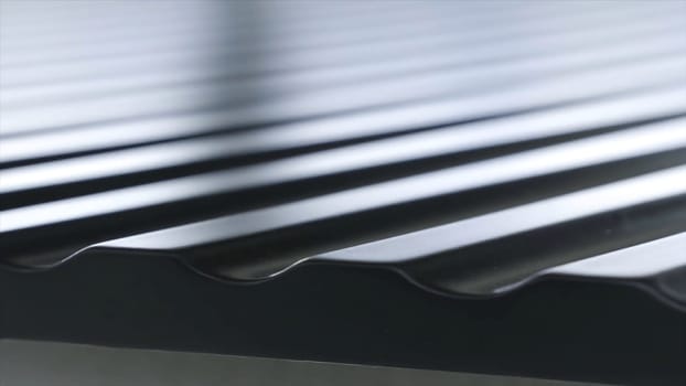 Close up view of black roofing waterproof material, construction and building concept. The edge of the roofing sheet, dark seam shingles.