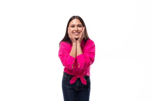 charming young brunette businesswoman dressed in pink smiling at the camera.