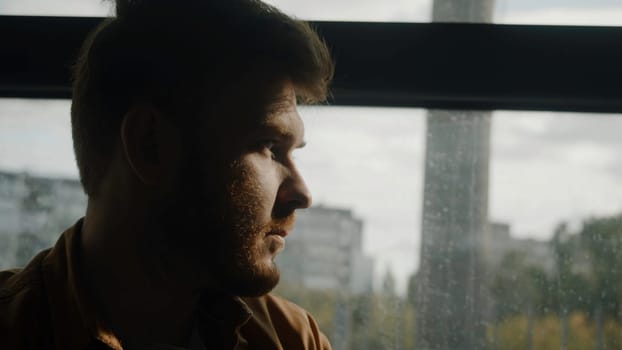 A beautiful portrait of a man. Stock footage. A man on a bus looks at the rays of the sun near the park. High quality 4k footage