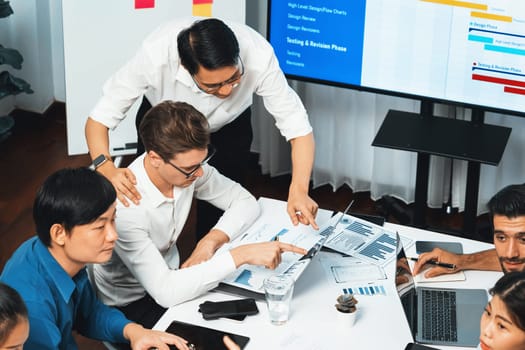 Analyst team utilizing BI Fintech to analyze financial data at table in meeting room. Businesspeople analyzing BI dashboard power on paper for business insight and strategic marketing planning.Prudent