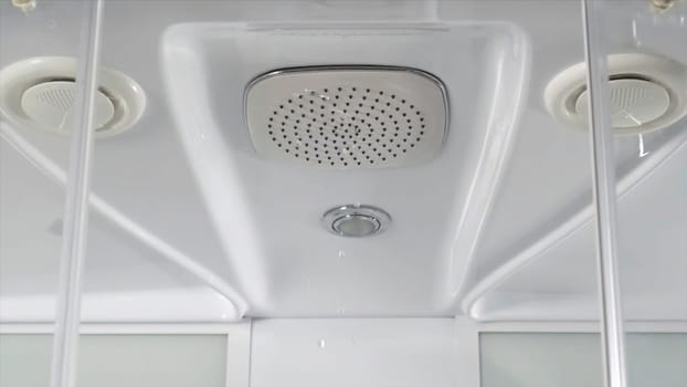 Water drops from shower head in bathroom on white background. close up of an square Italian head shower in a modern bathroom in slow motion. shower with water stream. Shower head HD