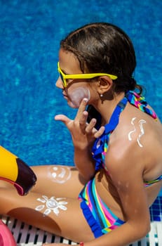 The child applies sunscreen. Selective focus. Kid.