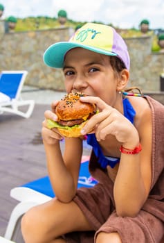 A child eats a burger. Selective focus. Kid.