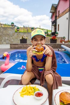 A child eats a burger. Selective focus. Kid.