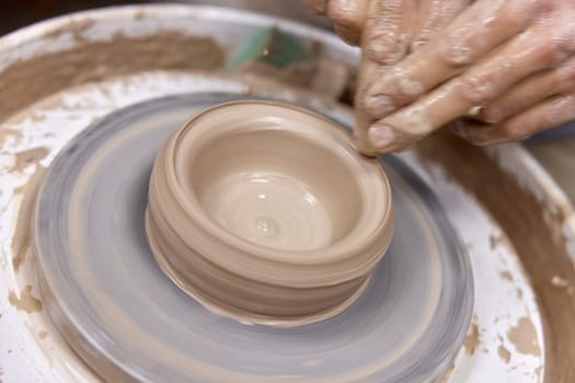 male hands making ceramic cup on pottery wheel, Close-up