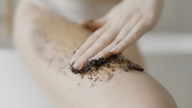 Close up of hands of a pretty blond girl with coffee scrub on them. Action. Beautiful woman during spa procedure