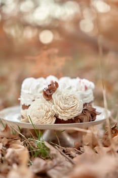 wedding cake with flowers on autumn fallen leaves outdoor