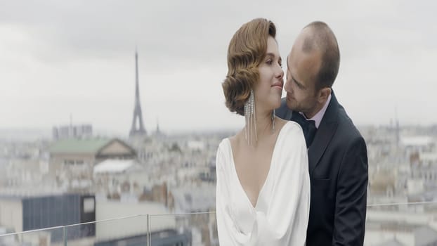 A beautiful couple against the background of nature and wind. Action. A beautiful brunette woman with curled hair and her love in a suit tenderly look at each other. High quality 4k footage