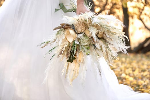 hands of the bride holding beautiful autumn bouquet