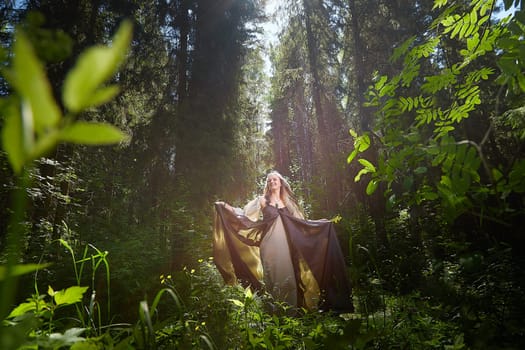 Beautiful seductive dryad. Pagan spirit of forest. Portrait of beautiful dryad. Fairy who loves nature in beautiful green summer forest. Concept of environmental friendliness and caring for nature