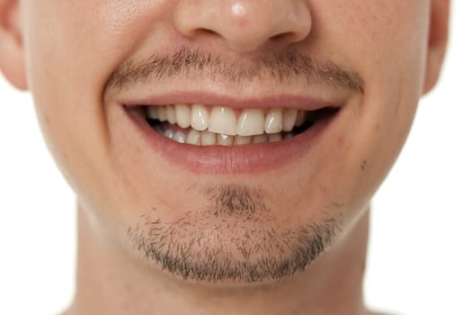 mouth and teeth of smiling man on studio background. male face with clean teeth