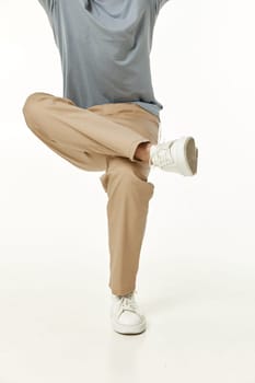 man sitting on invisible chair . guy in white sneakers and beige pants