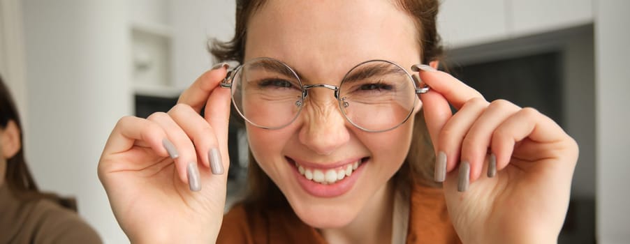 Close up portrait of attractive smiling woman with glasses, laughing and looking happy at camera.