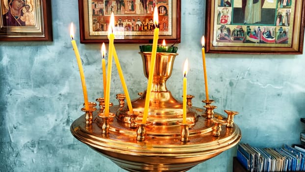 Kirov, Russia - April 16, 2023: Candles in a Christian Orthodox church background. Flame of candles in the dark sacred interior of the temple