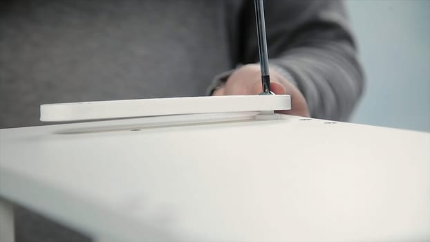 Man collects furniture in a workshop. Stock. Bonding and assembly of furniture on the wooden pins