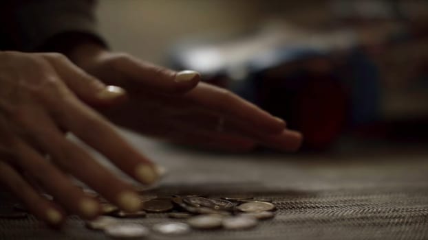 Close up for women hands putting money on the floor, saving money concept. Woman hands putting coins on the floor on blur background